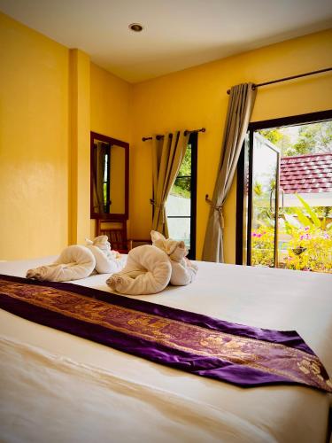 a bedroom with a bed with pillows and a window at Baan Ton Rak Boutique Resort in Ko Chang