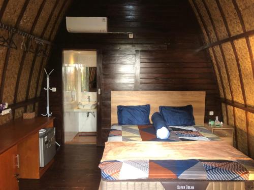 a bedroom with a bed with blue pillows at Villa RR Senggigi in Senggigi