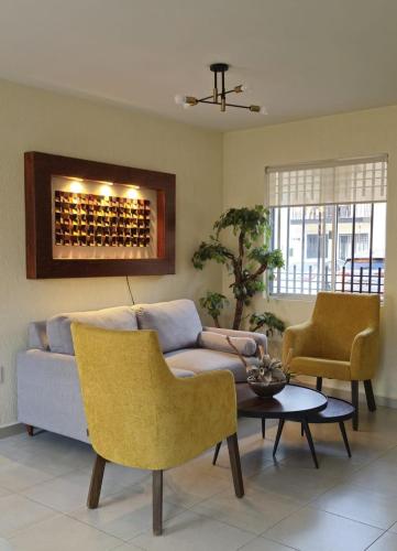 een woonkamer met een bank, stoelen en een tafel bij Casa Alta California Pet Friendly in Tlajomulco de Zúñiga