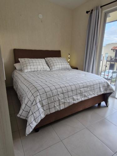 a bedroom with a bed and a window with a view at Casa Alta California in Tlajomulco de Zúñiga