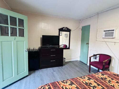 ein Schlafzimmer mit einem Bett und einem Fernseher auf einer Kommode in der Unterkunft Budget Motel in Manning