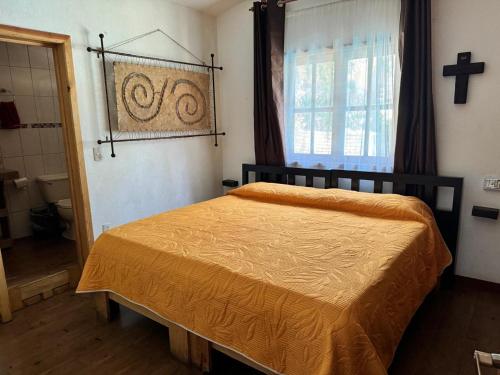 a bedroom with a bed and a cross on the wall at Cabaña Traslomita in Mazamitla