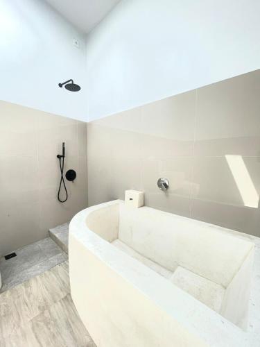 a white bathroom with a large tub in a room at The Sangka House in Mendaya