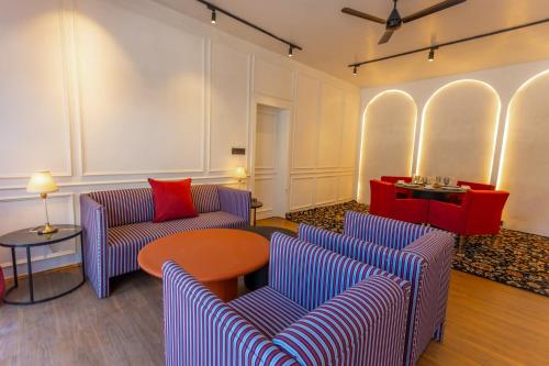 a living room with two couches and a table at The Zoey Villa, with Central Heating, Bonfire, BBQ & Complimentary Breakfast in Gulmarg