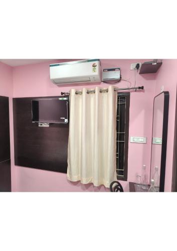 a bathroom with a shower curtain and a mirror at CHETTINAD HOMESTAy in Chidambaram