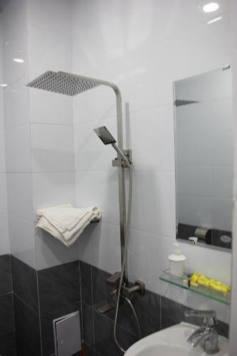 a bathroom with a shower with a sink and a mirror at Thu Van Apartment in Xuan An