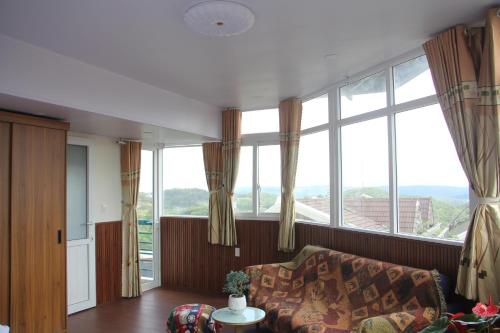a living room with a couch and large windows at Thu Van Apartment in Xuan An