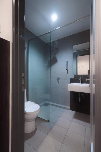 a bathroom with a toilet and a glass shower at T+ Hotel Sungai Korok in Alor Setar