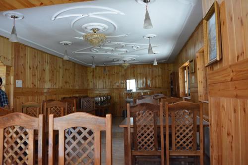 a dining room with wood paneling and a table and chairs at Hotel Barzman in Sonāmarg
