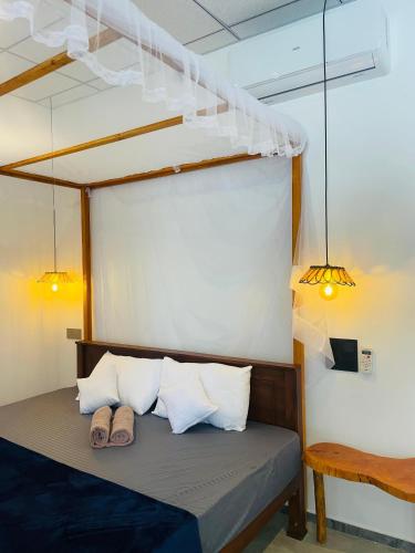 a bed in a room with two pairs of shoes at Crystal Wave in Weligama