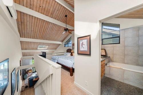 a room with a bed and a bathroom with a tub at Kahana Village 3 · KHV 3 Remodeled 2BD Condo with Oceanfront Lan in Kahana