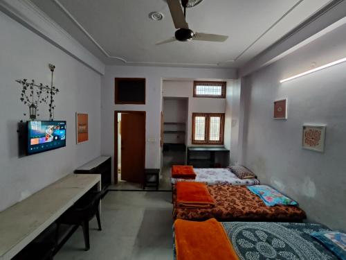 Una televisión o centro de entretenimiento en Neraine Niwas HomeStay