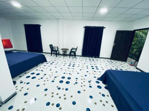 a bedroom with two beds and a table and chairs at Budget Room By Green House Resort in Sigiriya