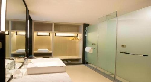 a bathroom with a glass shower and a sink at Echarm Hotel Changchun Yiqi Automotive Trade City Wanda in Changchun