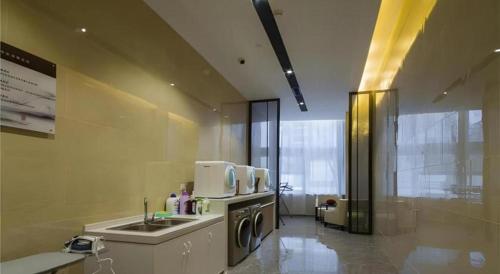 a kitchen with a sink and a washing machine at Echeng Hotel Changsha Evening News in Changsha