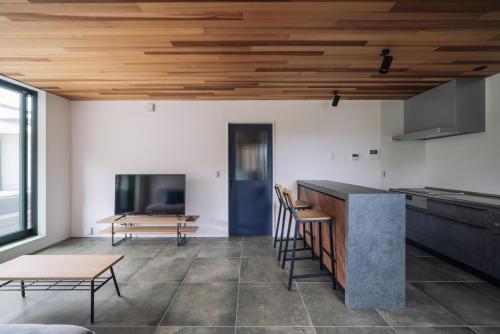 a kitchen with wooden ceilings and a table and chairs at Sanctuary Villa & Sauna Ogimi by Relapool in Banchi