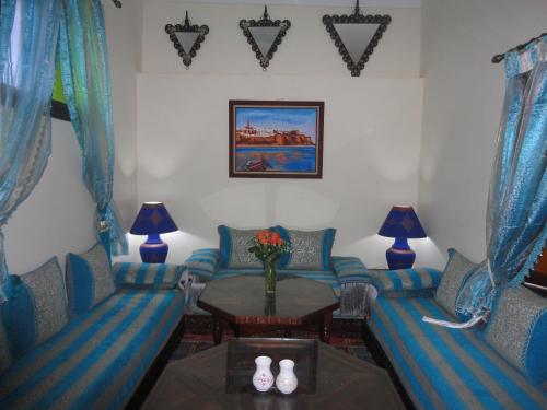a living room with blue couches and a table at Dar Yanis in Rabat