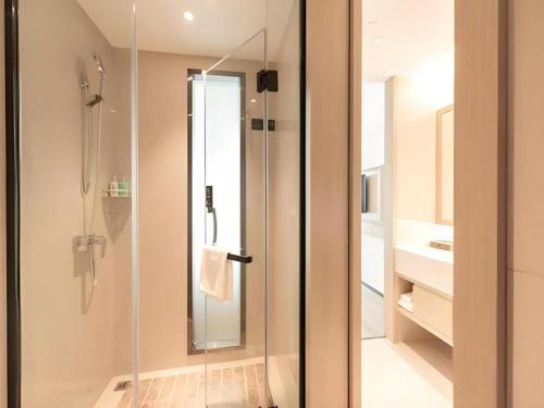 a bathroom with a shower with a glass door at City Comfort Inn Hefei Mingzhu Square Fanhua Avenue in Hefei