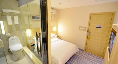 a bathroom with a bed and a toilet and a shower at City Comfort Inn Wuhan Zoo Guobo Maying Road Metro Station in Wuhan