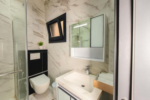 un bagno con lavandino, WC e specchio di Residence ACN 1B a Dakar