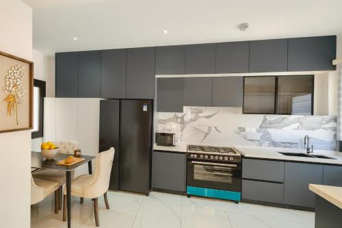 una cucina con fornelli, lavello e tavolo di Residence ACN 1B a Dakar