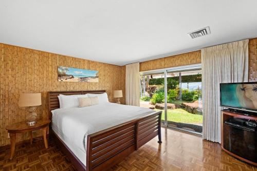 a bedroom with a bed and a flat screen tv at Hale Kalapu · Large Home 180° Ocean Views Walk2Beach Hale Kalapu in Kaanapali