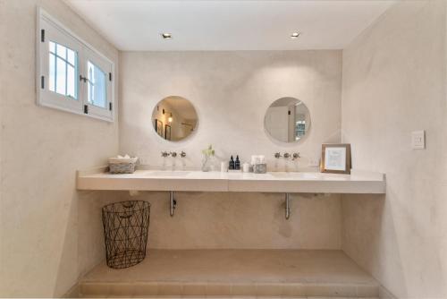 a bathroom with two sinks and two mirrors at Casa Damiana, Colonial Charm with Private Pool in Mérida