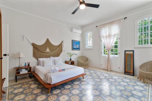 a bedroom with a large bed with a ceiling fan at Casa Damiana, Colonial Charm with Private Pool in Mérida