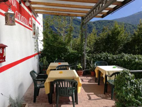 a patio with tables and chairs and mountains in the background at Locanda Chiocciola in Quero
