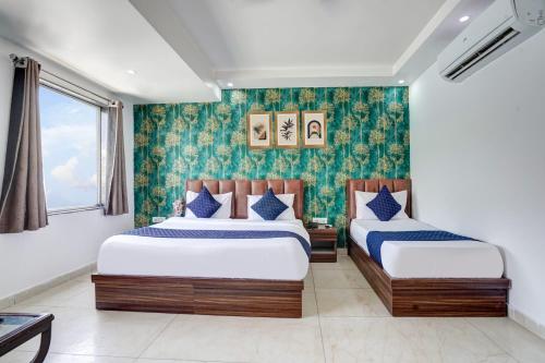a bedroom with two beds and a window at Hotel King Near Delhi Airport in New Delhi
