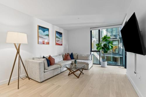a living room with a couch and a flat screen tv at Pearl Coast - Modern 2BR with Rooftop Pool & Views in Los Angeles