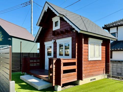 a tiny house with a porch and a deck at i GARDEN in Minami Alps