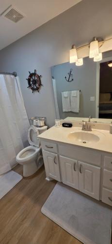 a bathroom with a sink and a toilet and a mirror at Nexton Nest in Summerville