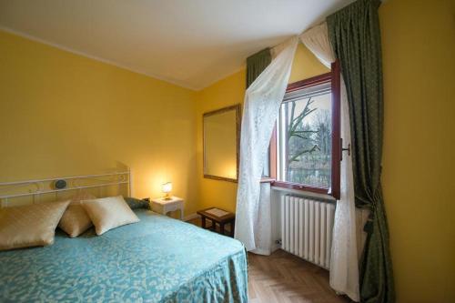 ein Schlafzimmer mit einem blauen Bett und einem Fenster in der Unterkunft B&B La Pescadora in Valeggio sul Mincio