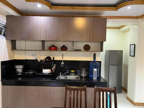 a kitchen with a black counter top and a refrigerator at TPRC Residences in Baguio
