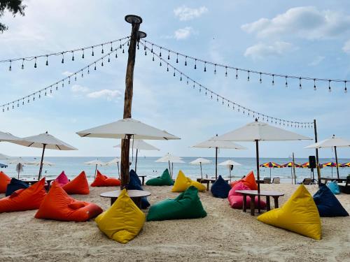 a beach with many colorful chairs and umbrellas at Seashell Family-222普吉岛木屋走几步到邦涛海滩看日落周边餐饮方便 in Bang Tao Beach