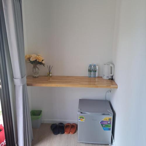 a small refrigerator in a room with a wooden shelf at Seashell Family-555普吉岛木屋走几步到邦涛海滩看日落周边餐饮方便 in Bang Tao Beach