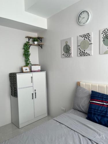 a bedroom with a bed with a white cabinet and a clock at Casa Mira Mandaue unit 608 Tower 4 in Cebu City