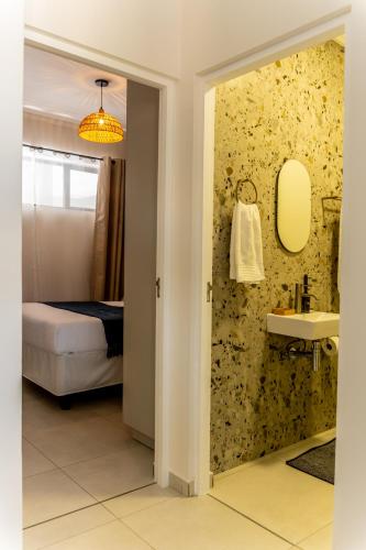 a bathroom with a bed and a sink and a mirror at Relax Wena in Fourways