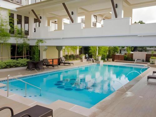 a large swimming pool with blue water in a building at Mansion Garden Hotel in Olongapo
