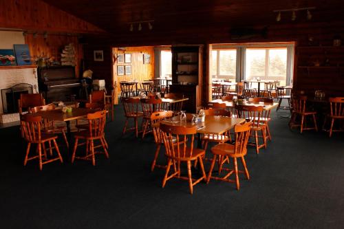 Brier Island Lodge في Westport: غرفة طعام مع طاولات وكراسي خشبية