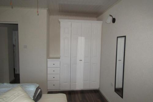 a bedroom with white cabinets and a bed and a mirror at BattsRock Beach Condos 205 in Saint Michael