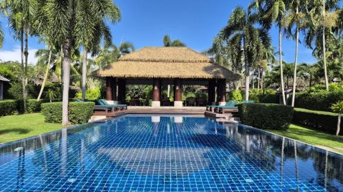 a swimming pool in front of a gazebo at Green Garden Villa Hotel in Nai Harn Beach