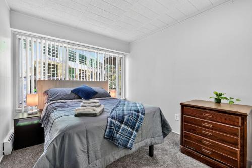 a bedroom with a bed with a dresser and a window at Game Day Ready Steps to Big House, U-M Campus & UM Hospital in Ann Arbor