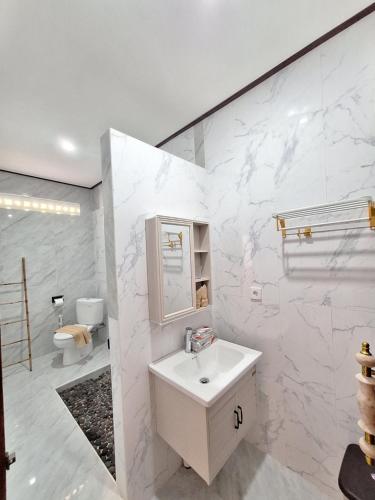 ein weißes Badezimmer mit Waschbecken und Toilette in der Unterkunft Tenang Villas - With Private Pool in Nusa Ceningan