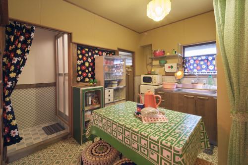 a kitchen with a table and a refrigerator in it at Retoro MeIeki 1號室 in Nagoya