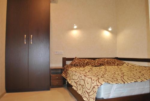 a bedroom with a bed and a wooden cabinet at Uytno in Chornomorsk