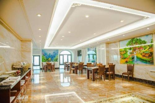 a dining room with a large painting on the wall at Bacninh Charming Hotel in Bồ Sơn