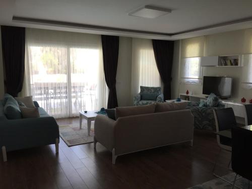 a living room with two couches and a television at Crescent Twins -White Villa in Dalyan