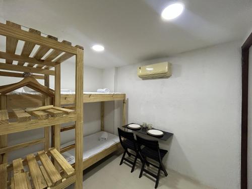a room with bunk beds and a table and chairs at Flat funcional mobiliado com cozinha com WC ap101 in Recife